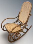 A bent wood and cane rocking chair,
