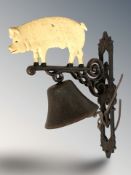 A cast iron pig wall bell on bracket, height 34 cm.