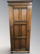 An oak linen fold sentry door cabinet, 76 cm x 43 cm x 181 cm.