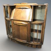 An Art Deco oak bureau, fitted cupboards to either side, 123 cm x 32 cm x 120 cm.