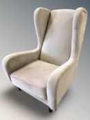 A modern wingback armchair in grey upholstery, width 86 cm.