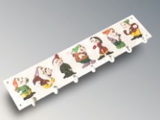 A cast iron seven dwarves coat rack, width 59 cm.