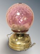 A late Victorian brass and cranberry glass oil lamp, height 41 cm.