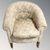 An early 20th century tub armchair in floral upholstery