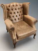 A 20th century Chesterfield style studded tan leather wingback armchair, width 98 cm.