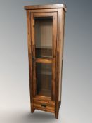 A contemporary glazed pine single door display cabinet, 55 cm W x 35 cm D x 180 cm H.