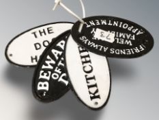 Four cast iron oval plaques including 'Beware of the dog', etc, each 17 cm wide.
