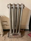 An early 20th century cast iron radiator height 102 cm x depth 16 cm x width 41 cm, on plinth base.