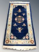 A Chinese fringed rug on blue ground, 210 cm x 92 cm.