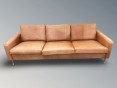 A late 20th century Danish tan leather three seater settee on chrome tapering legs,