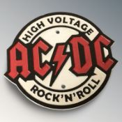 A cast iron AC/DC plaque, diameter 18 cm.