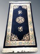 A Chinese fringed rug on blue ground, 204 cm x 92 cm.
