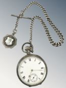 An antique silver pocket watch suspended on graduated silver Albert chain with enamel fob