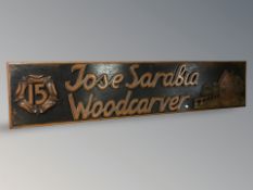 A wooden sign 'Jose Sarabla, Woodcarver', 180 cm x 39 cm.