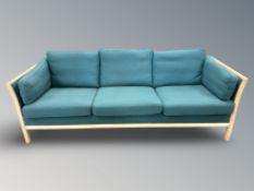 A late 20th century Danish wooden framed three settee in turquoise fabric,