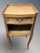 A reproduction French oak single drawer bedside stand,