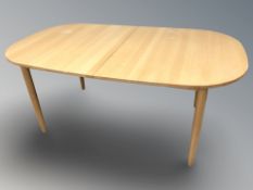 A contemporary beech extending dining table with internal leaf and a set of four spindle back