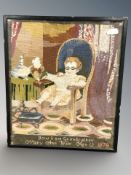 A Victorian needlework embroidery depicting a young boy reading the newspaper in an armchair titled