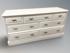 A modern painted seven drawer chest, 143 cm x 47 cm x 71 cm.