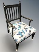 An ebonised low occasional chair