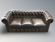 A Chesterfield buttoned brown leather three seater club settee, 188 cm x 85 cm x 74 cm,