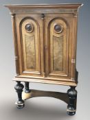 An early 20th century continental burr walnut and ebonised double door cabinet,
