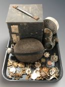 A gas mask, military canteen, assorted cap badges, etc.