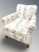 A contemporary armchair in floral upholstery.
