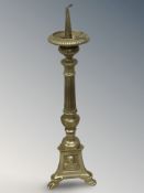 A brass pricket candlestick on paw feet, height 40 cm.