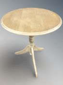 A reproduction tripod occasional table and an open armchair.