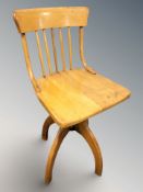 A 20th century pine spindle back rise and fall swivel chair