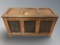 A reproduction heavily carved walnut blanket chest, 108 cm x 47 cm x 65 cm.