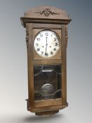 A Junghans carved oak eight day wall clock with silvered dial, length 83 cm.