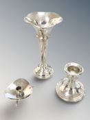 A silver squat candlestick, a loaded silver candlestick and a similar bud vase, height 13 cm.