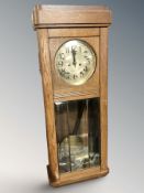 An early 20th century eight day wall clock with silvered dial, pendulum and weights, height 94 cm.