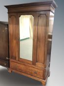 An Edwardian mahogany mirror door wardrobe, 136 cm x 55 cm x 205 cm.