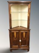 A reproduction yew wood corner cabinet with glass shelves,