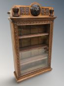 A late Victorian carved oak and glazed single door wall cabinet bearing initials 'G E 1900 1901',