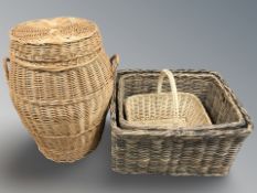 A wicker laundry hamper, height 70 cm, and three various baskets.