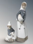 A Lladro figure of a lady holding a lamb No. 4584, and a further figure of a girl with a lamb.