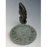 A carved golden obsidian Aztec style figurine and a reproduction Aztec calendar plaque,