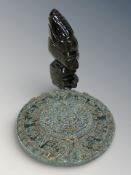 A carved golden obsidian Aztec style figurine and a reproduction Aztec calendar plaque,