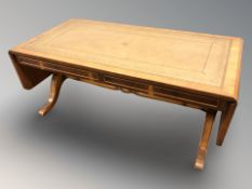 A reproduction yew wood drop leaf coffee table.