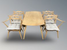 An Ercol elm and beech drop leaf extending oval dining table on splayed legs,