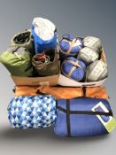 A group of camping supplies, some new with retail tags including sleeping bags, two person tent,