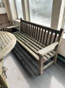 A weathered teak garden bench, length 192 cm.