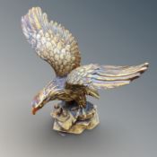 A resin figure of an eagle on rock, height 31 cm.
