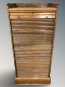 An early 20th century oak tambour front cabinet,