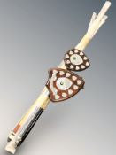 A group of billiards cues and two trophy plaques.