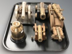 Four brass miniature model cannons on carriages, a further similar example and a miniature churn.